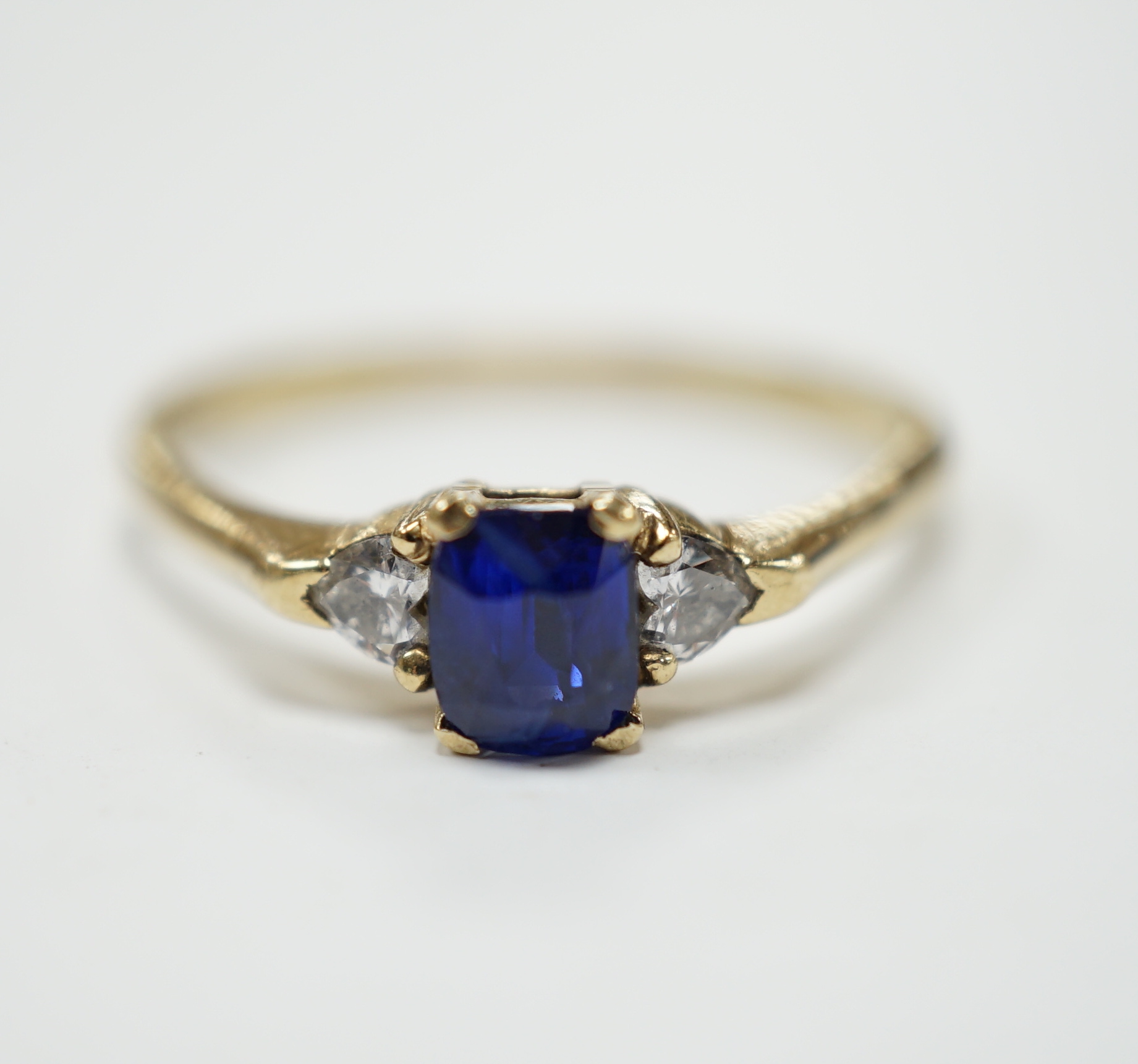 A yellow metal and single stone oval cut sapphire set ring, with two stone heart shaped diamond set shoulders, size U/V, gross weight 2.4 grams.